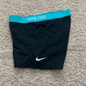 Black Nike pros with teal waistband